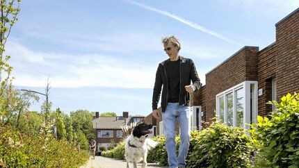 Man loopt langs woningen