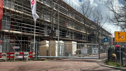 nieuwbouwcomplex met wapperende vlag hoogste punt