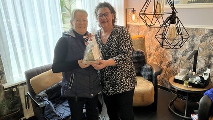 twee buren omarmen elkaar met beste buuraward in de hand