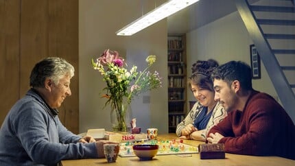 Gezin aan tafel met bordspel